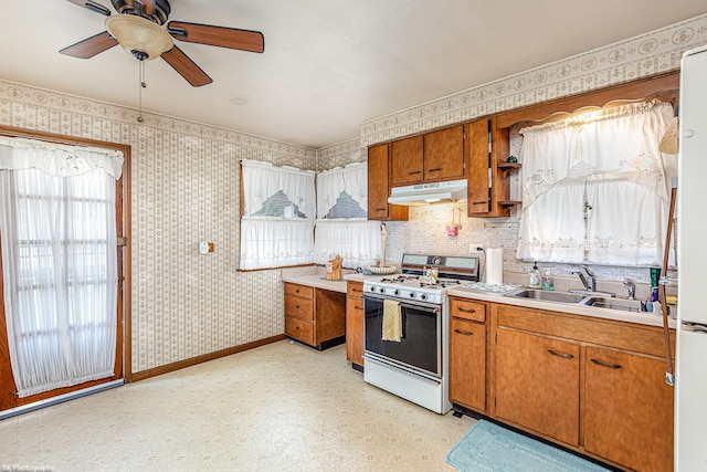 3855 W 107th St, Chicago, IL 60655 - kitchen with white appliances, under cabinet range hood, brown cabinets, light countertops, and wallpapered walls