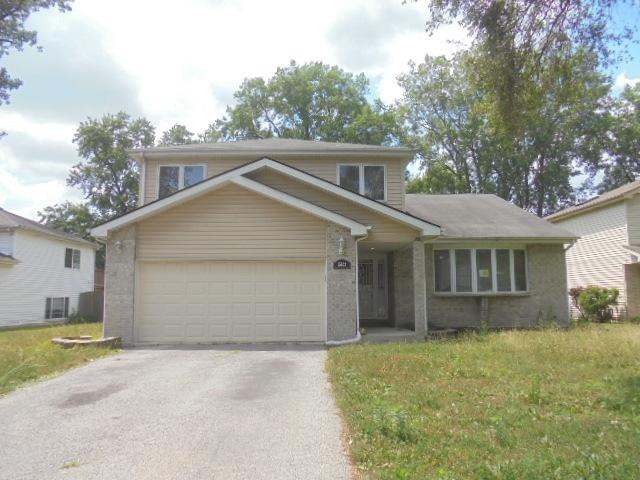 15624 Sawyer Ave, Markham, IL 60428 - traditional-style house with driveway, an attached garage, a front lawn, and brick siding
