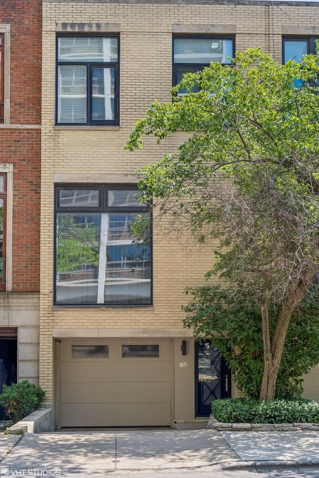 65 W Schiller St, Chicago, IL 60610 - view of building exterior with a garage and concrete driveway