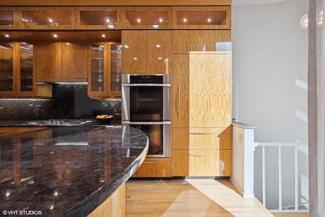65 W Schiller St, Chicago, IL 60610 - kitchen with stainless steel appliances, decorative backsplash, dark stone counters, glass insert cabinets, and modern cabinets