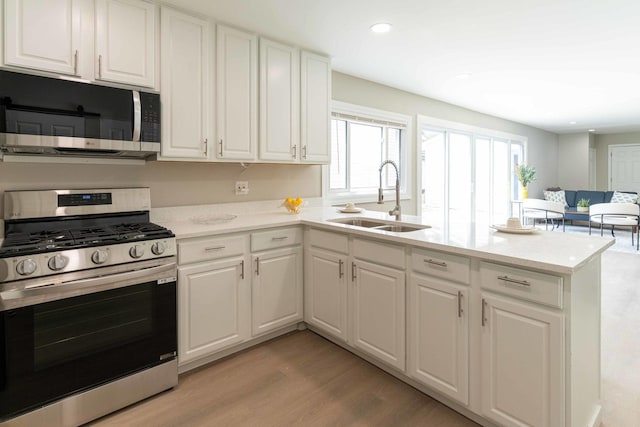 129 Highbury Dr, Elgin, IL 60120 - kitchen featuring stainless steel appliances, white cabinetry, a peninsula, light wood-type flooring, and recessed lighting