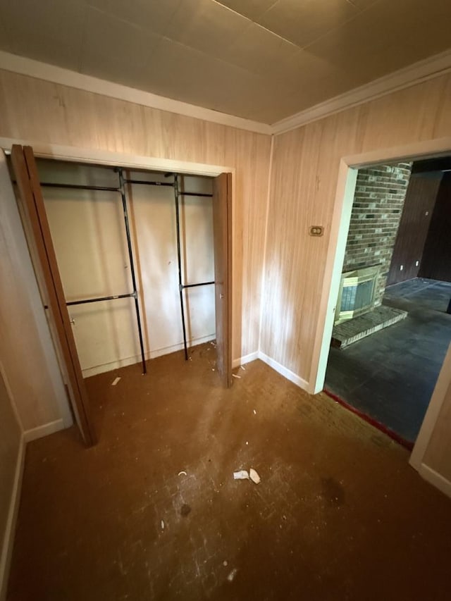 24576 W Norelius Ave, Round Lake, IL 60073 - unfurnished bedroom featuring unfinished concrete floors, a fireplace, wood walls, and ornamental molding