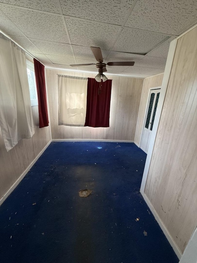 24576 W Norelius Ave, Round Lake, IL 60073 - empty room with wooden walls, a paneled ceiling, and a ceiling fan