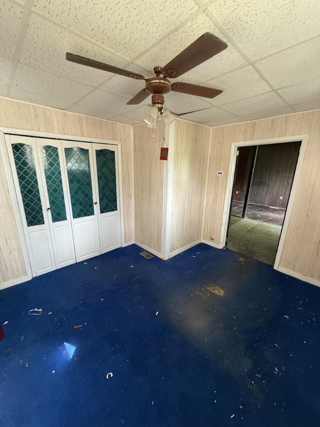 24576 W Norelius Ave, Round Lake, IL 60073 - spare room featuring a drop ceiling, wooden walls, and a ceiling fan