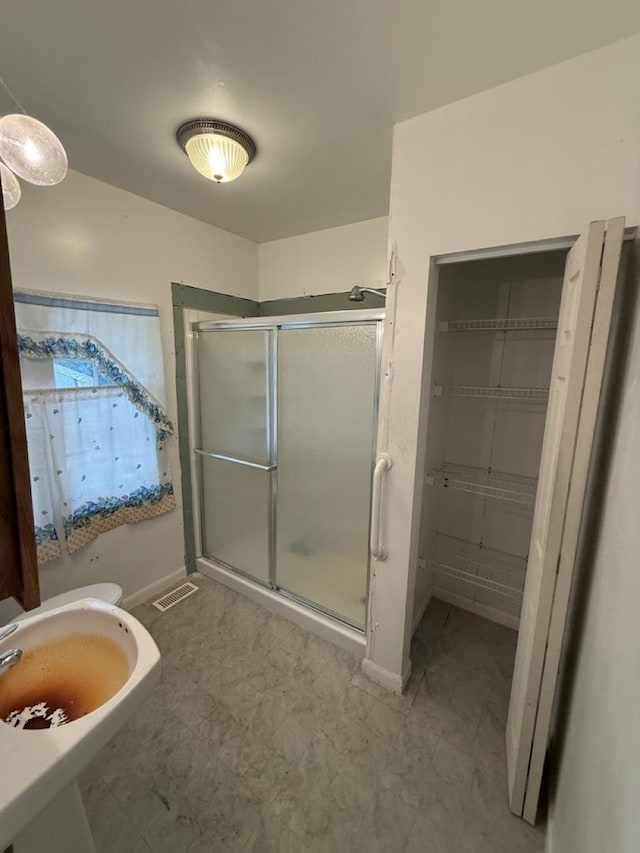 24576 W Norelius Ave, Round Lake, IL 60073 - bathroom featuring a stall shower and baseboards