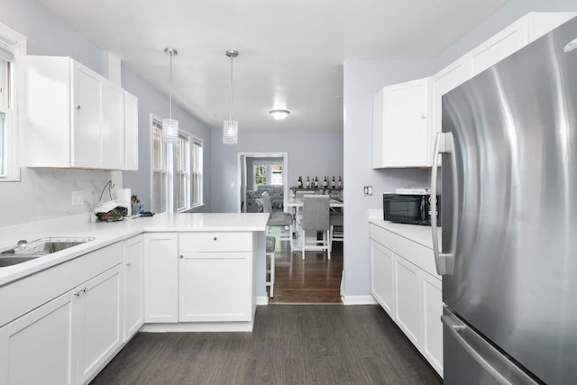 5217 S Green St, Chicago, IL 60609 - kitchen featuring freestanding refrigerator, black microwave, dark wood-style flooring, a peninsula, and white cabinetry