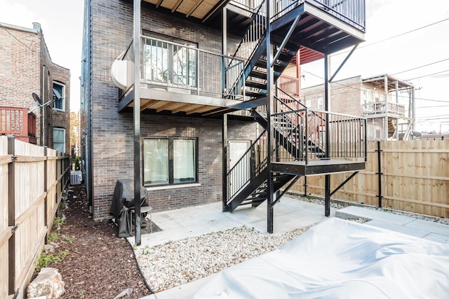 4634 S Langley Ave, Chicago, IL 60653 - rear view of property with stairway, a fenced backyard, brick siding, and a patio