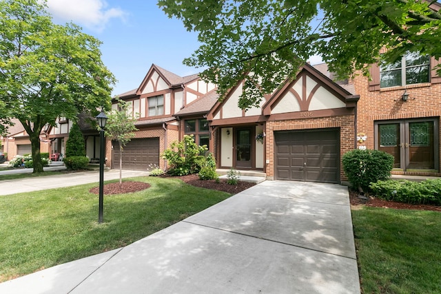 11016 Eaton Ct, Westchester, IL 60154 - tudor-style house with concrete driveway, brick siding, a front lawn, and stucco siding