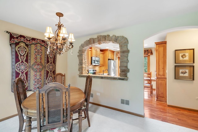 11016 Eaton Ct, Westchester, IL 60154 - dining area with arched walkways, a chandelier, and light wood-type flooring