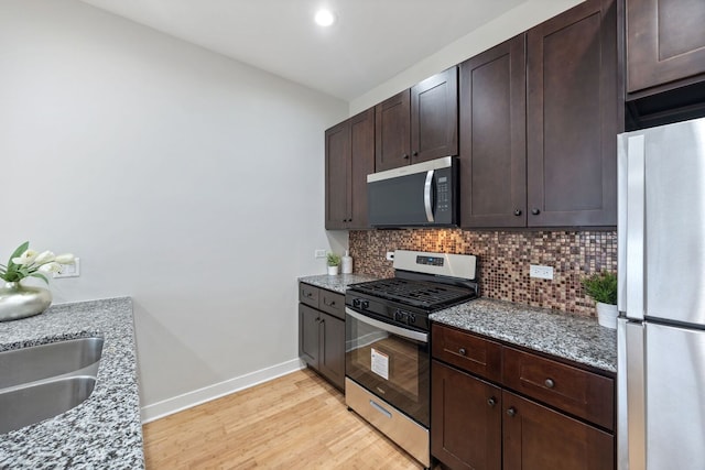 3130 W Walton St Unit 3, Chicago, IL 60622 - kitchen with stainless steel appliances, tasteful backsplash, light wood finished floors, dark brown cabinets, and light stone counters