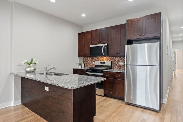 3130 W Walton St Unit 3, Chicago, IL 60622 - kitchen featuring stainless steel appliances, dark brown cabinetry, light wood-type flooring, light stone countertops, and decorative backsplash