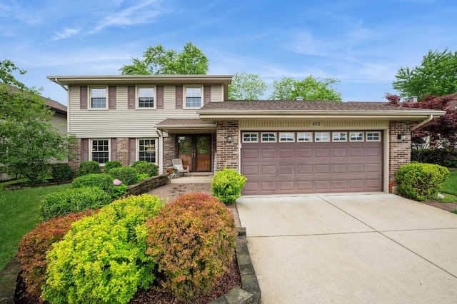 872 Asbury Ln, Schaumburg, IL 60193 - view of front of house with brick siding, concrete driveway, and a garage