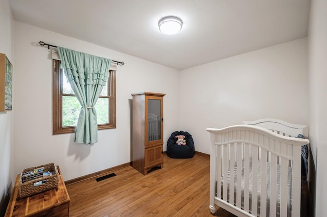 872 Asbury Ln, Schaumburg, IL 60193 - bedroom featuring light wood-style flooring and a nursery area