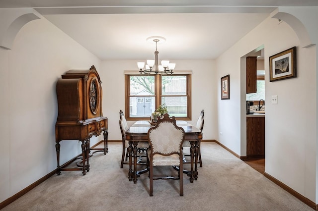 872 Asbury Ln, Schaumburg, IL 60193 - dining room featuring arched walkways, light colored carpet, and a chandelier