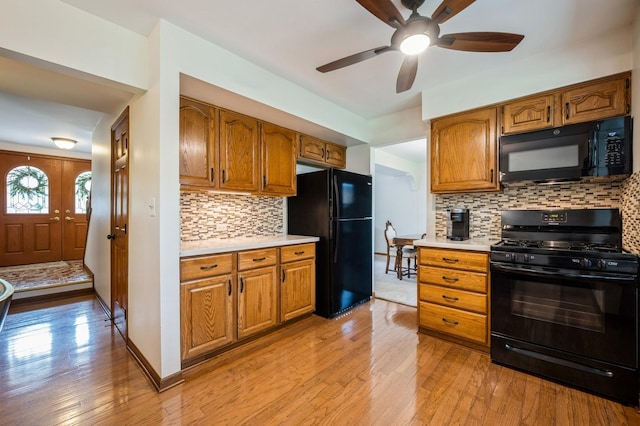 872 Asbury Ln, Schaumburg, IL 60193 - kitchen featuring black appliances, light countertops, light wood finished floors, and brown cabinets