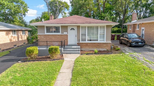 293 Hickory St, Chicago Heights, IL 60411 - bungalow with brick siding, a chimney, a front lawn, and asphalt driveway