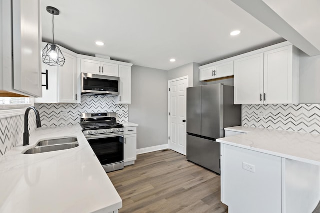 293 Hickory St, Chicago Heights, IL 60411 - kitchen featuring stainless steel appliances, tasteful backsplash, white cabinetry, pendant lighting, and light wood-style floors