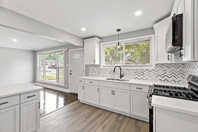 293 Hickory St, Chicago Heights, IL 60411 - kitchen with stainless steel gas range oven, white cabinetry, tasteful backsplash, light wood finished floors, and pendant lighting