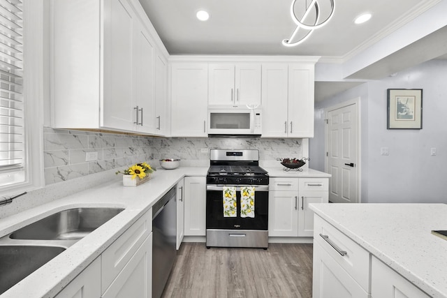 3039 S Kolin Ave, Chicago, IL 60623 - kitchen with appliances with stainless steel finishes, white cabinetry, light wood-type flooring, light stone counters, and recessed lighting