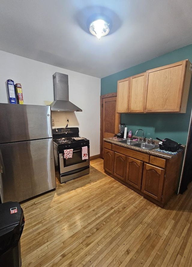5330 S California Ave, Chicago, IL 60632 - kitchen with wall chimney range hood, range with gas cooktop, freestanding refrigerator, light wood-style floors, and dark countertops