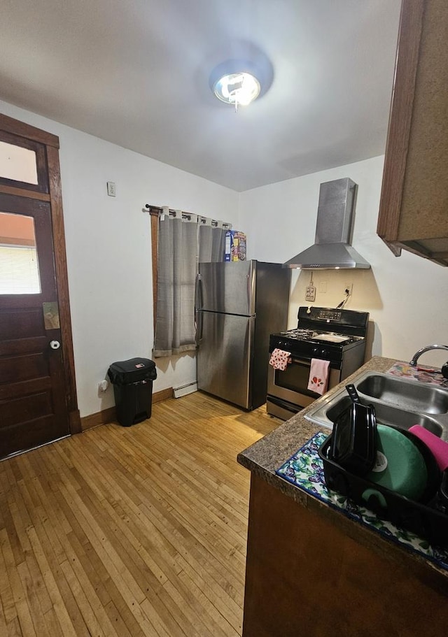 5330 S California Ave, Chicago, IL 60632 - kitchen with wall chimney exhaust hood, range with gas stovetop, freestanding refrigerator, and light wood finished floors