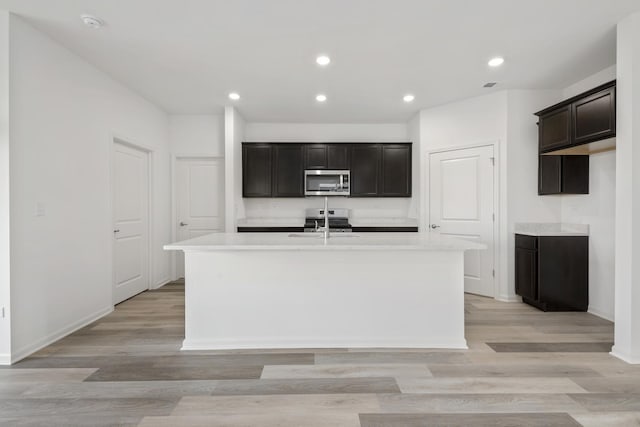 14628 S Azalia Cir, Plainfield, IL 60544 - kitchen featuring stainless steel appliances, a center island with sink, light countertops, light wood finished floors, and recessed lighting