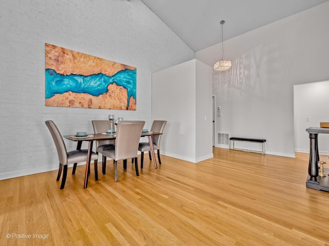 1039 Deerfield Pl Unit 1039, Highland Park, IL 60035 - dining room with wood finished floors, a towering ceiling, and brick wall