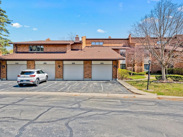 1039 Deerfield Pl Unit 1039, Highland Park, IL 60035 - view of front of home featuring brick siding, community garages, and a chimney