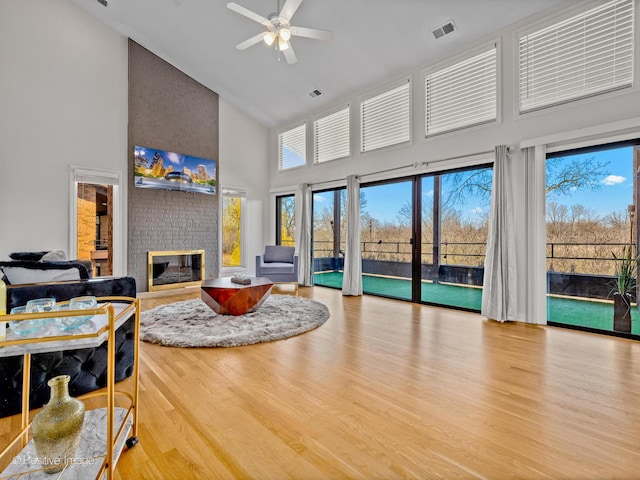 1039 Deerfield Pl Unit 1039, Highland Park, IL 60035 - living room with high vaulted ceiling, a brick fireplace, wood finished floors, and a ceiling fan