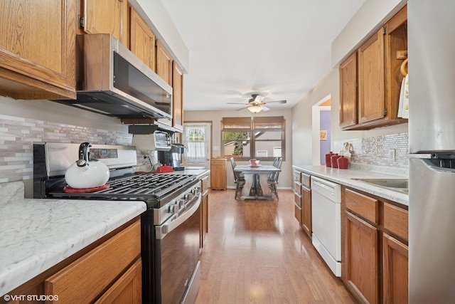 1713 Meadow Ln, Mchenry, IL 60050 - kitchen featuring stainless steel appliances, a ceiling fan, tasteful backsplash, light countertops, and brown cabinetry