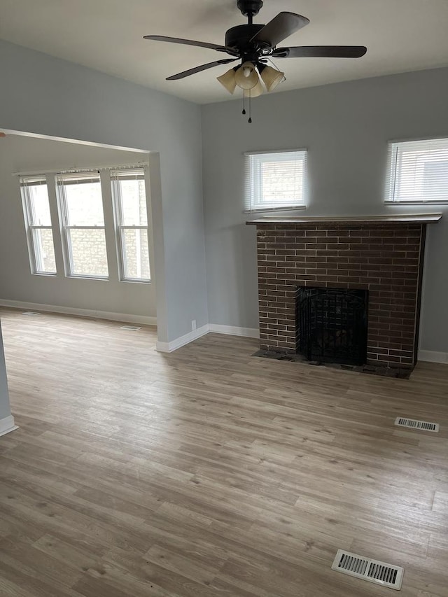 7535 S Vernon Ave, Chicago, IL 60619 - unfurnished living room featuring a fireplace, plenty of natural light, a ceiling fan, and wood finished floors