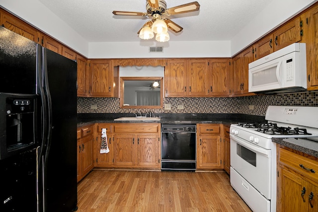 947 Winter Park Dr Unit 947, New Lenox, IL 60451 - kitchen featuring ceiling fan, black appliances, brown cabinetry, dark countertops, and a textured ceiling