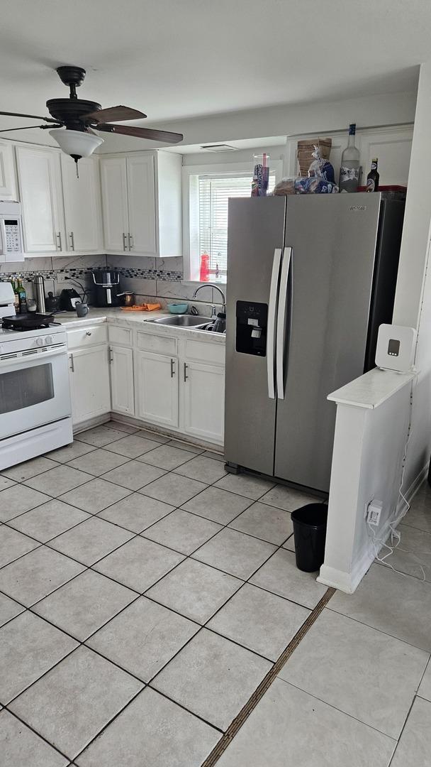 3201 Armitage Ave, Melrose Park, IL 60160 - kitchen with white appliances, white cabinets, decorative backsplash, and light countertops