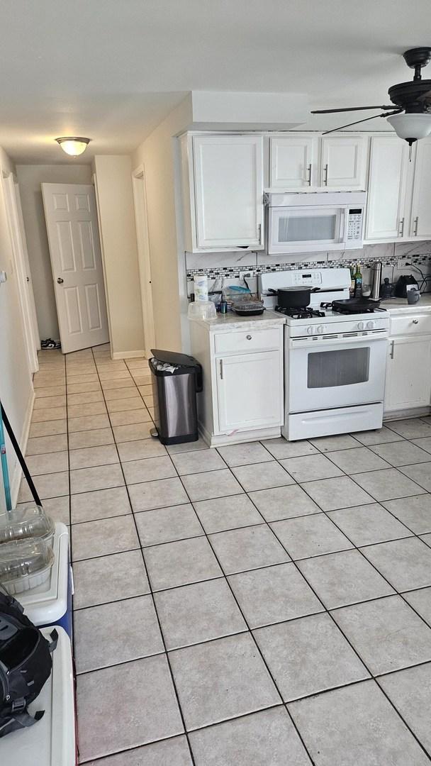3201 Armitage Ave, Melrose Park, IL 60160 - kitchen featuring white appliances, light tile patterned floors, white cabinetry, a ceiling fan, and light countertops