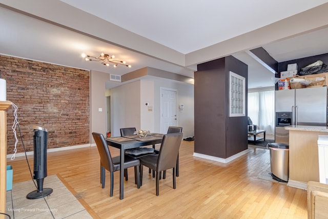 1423 E 68th St Unit 2, Chicago, IL 60637 - dining room with light wood finished floors and brick wall