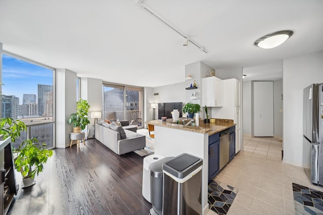222 N Columbus Dr Unit 3702, Chicago, IL 60601 - kitchen featuring stainless steel appliances, open floor plan, blue cabinets, white cabinetry, and open shelves