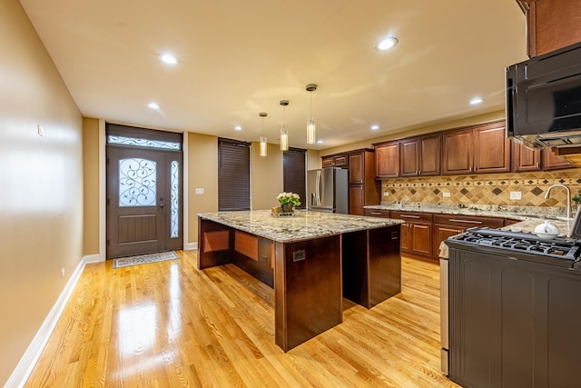 2012 W Coulter St, Chicago, IL 60608 - kitchen with a kitchen island, light wood-style floors, range with gas stovetop, tasteful backsplash, and recessed lighting