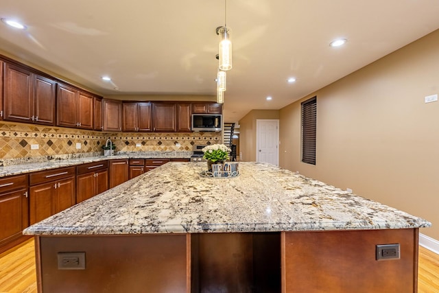 2012 W Coulter St, Chicago, IL 60608 - kitchen featuring a center island, light wood-style flooring, backsplash, light stone countertops, and recessed lighting
