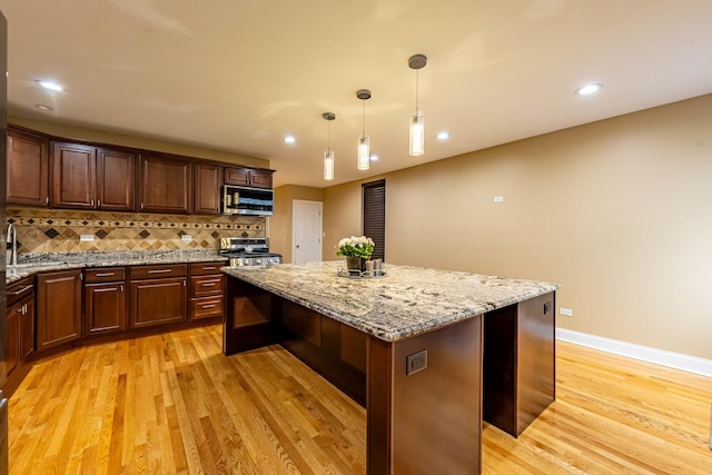 2012 W Coulter St, Chicago, IL 60608 - kitchen featuring a kitchen island, light wood finished floors, stainless steel appliances, tasteful backsplash, and recessed lighting