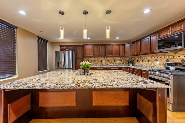 2012 W Coulter St, Chicago, IL 60608 - kitchen with stainless steel appliances, a large island, tasteful backsplash, light stone counters, and recessed lighting