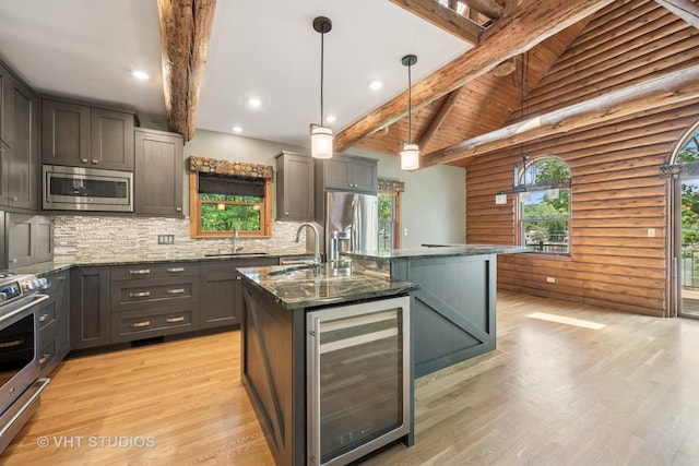 723 N River Rd, Algonquin, IL 60102 - kitchen featuring beverage cooler, stainless steel appliances, dark stone counters, beamed ceiling, and a center island with sink