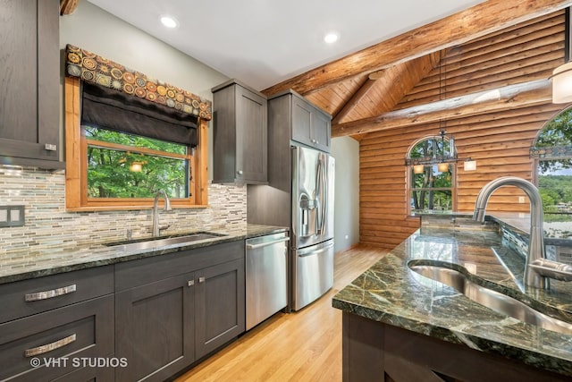 723 N River Rd, Algonquin, IL 60102 - kitchen with appliances with stainless steel finishes, light wood-style flooring, backsplash, dark stone counters, and log walls
