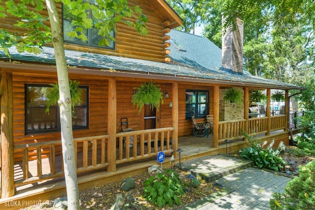 723 N River Rd, Algonquin, IL 60102 - doorway to property featuring covered porch, a chimney, and log siding