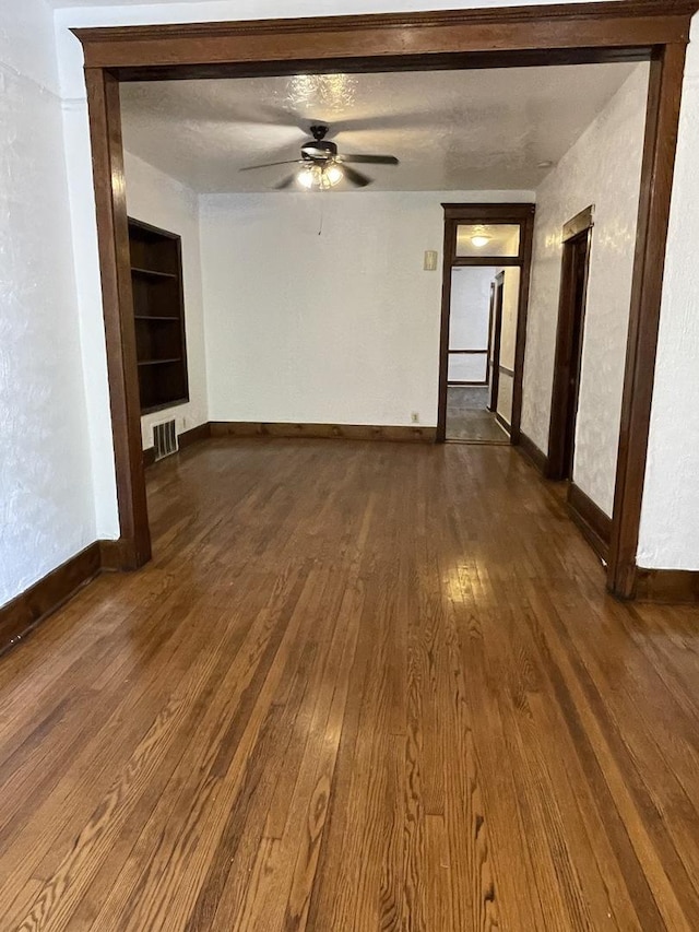 2724 W Flournoy St, Chicago, IL 60624 - empty room with dark wood-style flooring, a ceiling fan, and built in features