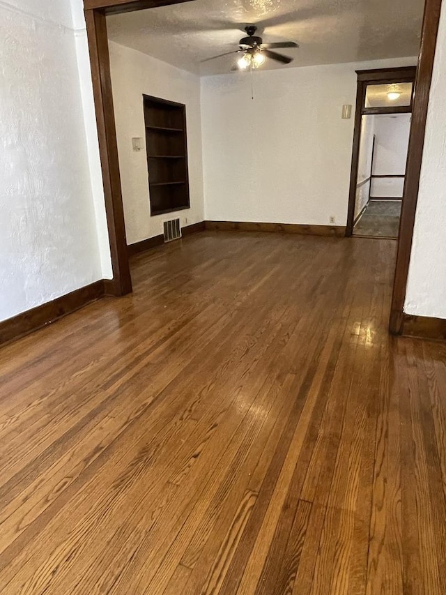 2724 W Flournoy St, Chicago, IL 60624 - unfurnished living room with built in shelves, dark wood-style floors, and a ceiling fan