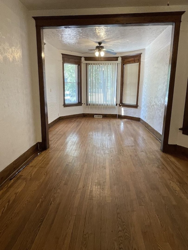 2724 W Flournoy St, Chicago, IL 60624 - empty room featuring dark wood-style flooring, ceiling fan, and a textured wall