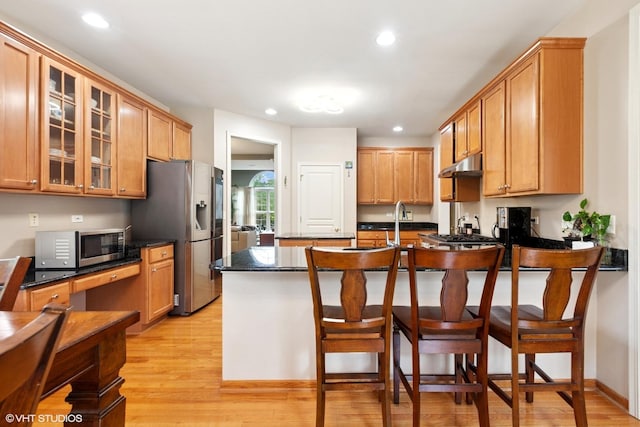 2701 Hamman Way, Aurora, IL 60502 - kitchen with light wood-style floors, glass insert cabinets, a kitchen bar, appliances with stainless steel finishes, and a peninsula