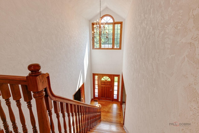 520 Holdridge Ave, Winthrop Harbor, IL 60096 - stairway with lofted ceiling, wood finished floors, a chandelier, and a textured wall