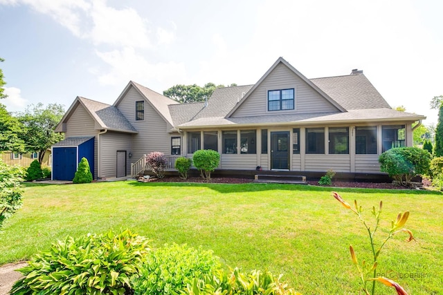 520 Holdridge Ave, Winthrop Harbor, IL 60096 - view of front of home with a sunroom, a storage unit, roof with shingles, and a front lawn