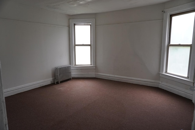 7225 S Princeton Ave, Chicago, IL 60621 - empty room featuring radiator heating unit, dark colored carpet, and healthy amount of natural light